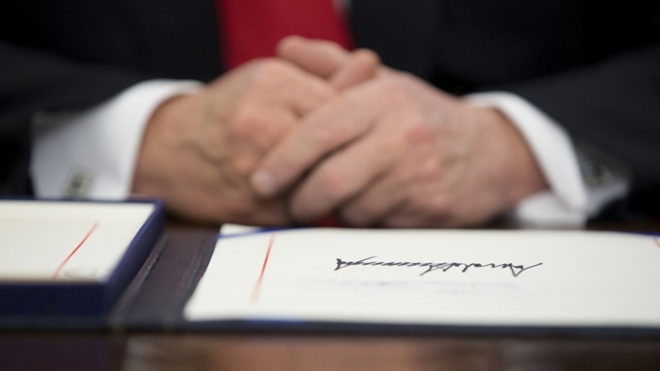 La signature de Trump sur les billets en dollars : personnalisation de la monnaie et conséquences pour les institutions